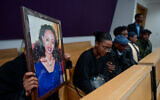 Mastwell Mandparo's relatives hold her photo during the sentencing of her husband, convicted of her 2020 murder, at the Tel Aviv District Court, January 4, 2023. (Avshalom Sassoni/Flash90)