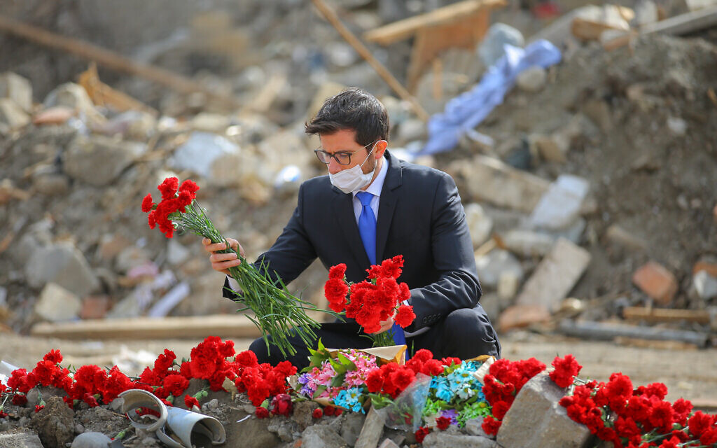 Israeli Ambassador to Azerbaijan George Deek lays flowers near destroyed buildings in the city of Ganja after it was hit by Armenian missiles, October 2020. (Courtesy of Israeli Embassy in Baku)