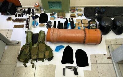 Several items, among them handguns, ammunition, and a bulletproof vest, seized as part of a police crackdown on organized crime in northern Israel, January 8, 2023. (Israel Police)
