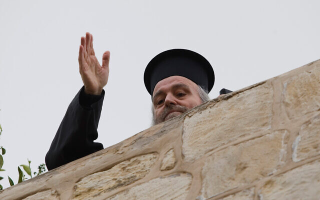 Former Greek Patriarch Irineos I waves from the rooftop of his apartment in the Old City of Jerusalem, January 6, 2011. (AP/Dan Balilty)