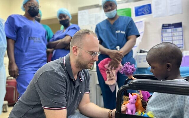 Dr. Mattan Arazi, ophthalmology resident at Sheba medical Center, consulting with a child in Nigeria as part of a humanitarian mission on January 10, 2023. (Courtesy: Sheba Medical Center)