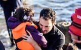 IsraAid CEO Yotam Polizer aids a Syrian refugee in Lesbos, Greece, in 2015 (courtesy of IsraAid)