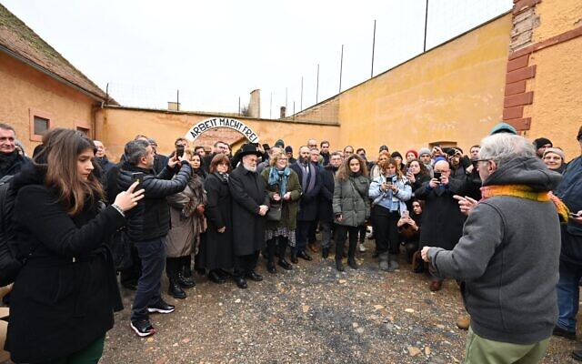 Holocaust survivor Gidon Lev speaks about the meaning of the 'Arbeit Macht Frei' sign at the former Theresienstadt ghetto-concentration camp, pictured on January 24, 2023. (Courtesy EJA)