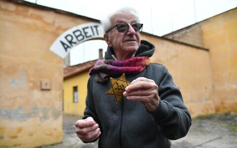 Holocaust survivor Gidon Lev holds his mother's yellow star at the former Theresienstadt ghetto-concentration camp, pictured on January 24, 2023. (Courtesy EJA)