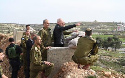 Defense Minister Yoav Gallant points at a Palestinian village outside the IDF's West Bank headquarters, January 29, 2023. (Ariel Hermoni/Defense Ministry)