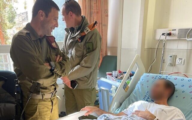 The commander of the IDF's West Bank Division, Brig. Ben. Avi Blot, visits Lt. 'Aleph,' in November 2022 after he was wounded in a ramming attack at a West Bank checkpoint. (Israel Defense Forces)