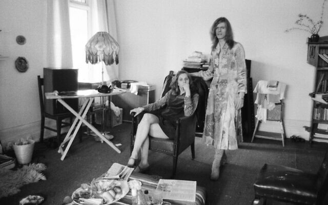 David Bowie, shown with his wife Angie at home in Kent, England, in 1971, is wearing a dress that he famously wore on the cover of his 'The Man Who Sold the World' album. (Peter Stone/Mirrorpix/Getty Images via JTA)