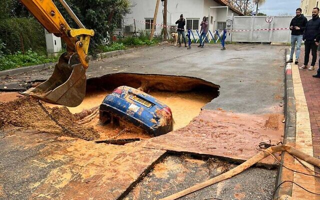 A car inside a sinkhole in the central town of Hod Hasharon, January 14, 2022. (Israel Police)