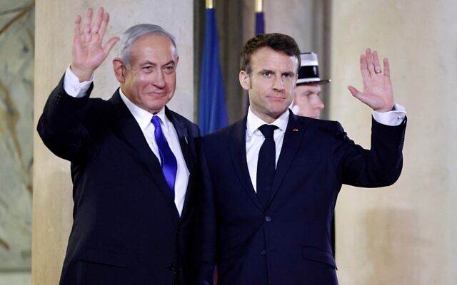 Prime Minister Benjamin Netanyahu (L) and French President Emmanuel Macron (R) gesture prior to a working dinner at the Presidential Elysee Palace in Paris on February 2, 2023. (Ludovic Marin/AFP)