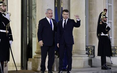 France's President Emmanuel Macron (R) gestures as he welcomes Prime Minister Benjamin Netanyahu (L), prior to a working dinner at the Presidential Elysee Palace in Paris on February 2, 2023. (Ludovic MARIN / AFP)