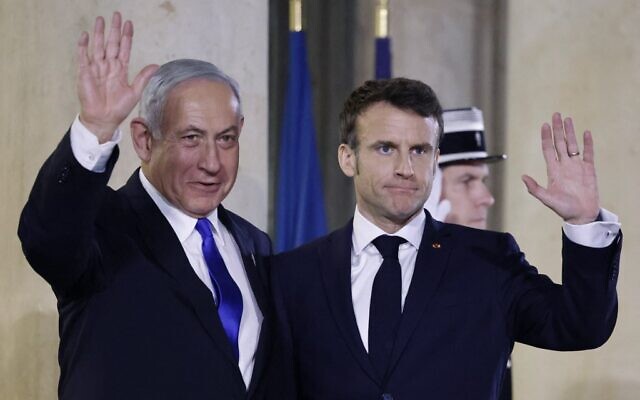 Prime Minister Benjamin Netanyahu (L) and French President Emmanuel Macron (R) gesture prior to a working dinner at the Presidential Elysee Palace in Paris on February 2, 2023. (Ludovic Marin/AFP)