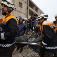 Members of the Syrian Civil Defence, or White Helmets, transport a casualty pulled from the rubble following an earthquake in the town of Zardana in the countryside of the northwestern Syrian Idlib province, February 6, 2023. (Abdulaziz KETAZ/AFP)