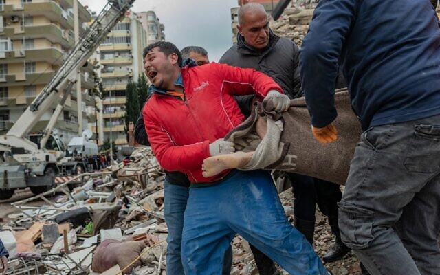 A rescuer reacts as he carries a body found in the rubble in Adana on February 6, 2023, after a 7.8-magnitude earthquake struck the country's south-east. (Can EROK / AFP)