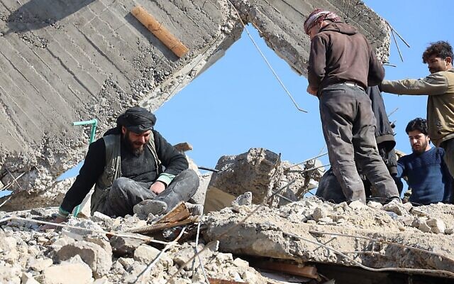 A Syrian man cries as he sits above the rubble of a collapsed building on February 7, 2023 in the town of Jandaris, in the rebel-held part of Aleppo province, following a deadly earthquake (Mohammed AL-RIFAI / AFP)