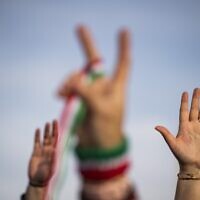 People raise their hands during a demonstration to denounce the Iranian government at the Lincoln Memorial in Washington, DC, on February 11, 2023. (Roberto Schmidt / AFP)