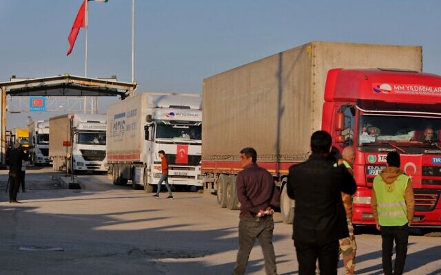 Trucks part of an earthquake aid convoy cross from Turkey into rebel-held north Syria through the Bab al-Salama crossing on February 14, 2023, after it reopened for UN relief. (Bakr Alkasem/AFP)