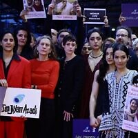 Berlinale Executive Director Mariette Rissenbeek, US actress and Berlinale Jury President Kristen Stewart, Iranian-French actress and jury member Golshifteh Farahani, and others hold  placards reading "Woman Life Freedom" during a protest in solidarity with protesters in Iran, on the red carpet at the Berlinale on February 18, 2023, in Berlin. (John MacDougall/AFP)