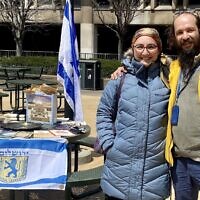 Rabbi Alexander Popivker (right) with his wife, Sarah, mounting a pro-Israel display on the campus of Cleveland State University. (Courtesy of Alex Popivker via JTA)
