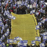 Demonstrators carry a massive Declaration of Independence during a rally in Tel Aviv to protest the Israeli government's planned overhaul of the judicial system, on February 18, 2023. (Tomer Neuberg/Flash90)