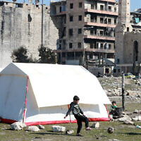 Children, displaced as a result of the earthquake that hit Turkey and Syria earlier this month, play football outside a tent at a make shift camp in Bustan al-Basha neighborhood in the government-held northern city of Aleppo, Syria, on February 20, 2023. (LOUAI BESHARA/AFP)