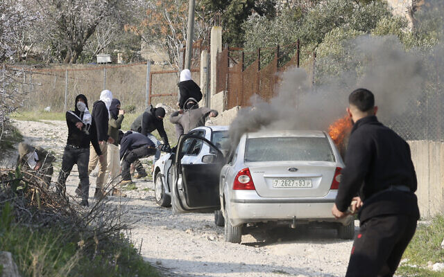 Israeli settlers hurl stones and set fire to cars in the village of Burin, in the northern West Bank on February 25, 2023. (Jaafar ASHTIYEH / AFP)