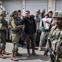 Illustrative: Israeli soldiers speak with Israeli settlers in the West Bank town of Huwara near Nablus on February 27, 2023. (RONALDO SCHEMIDT / AFP)