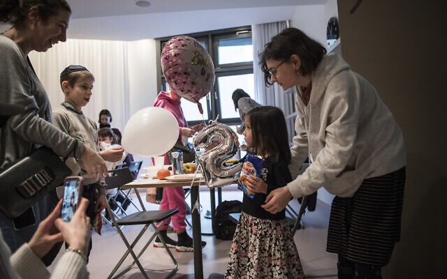 Sada, second from right, gets a balloon on her birthday after she arrived from an orphanage in Odesa, Ukraine, at a hotel in Berlin, Friday, March 4, 2022. (AP/Steffi Loos)