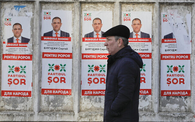 A man walks by electoral posters advertising the candidates of the Shor Party, led by Israeli-born Moldovan businessman Ilan Shor, in Chisinau, Moldova, February 21, 2019. (AP Photo/Vadim Ghirda)
