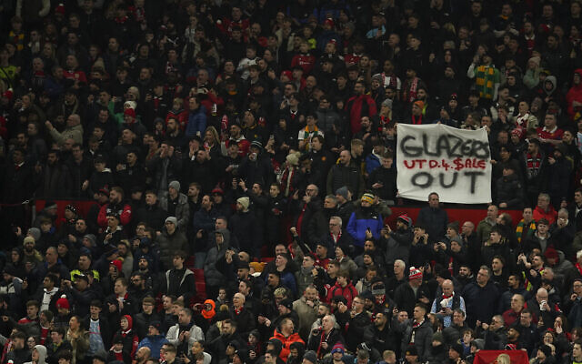 An anti-Glazer family banner is held up by members of the crowd before the English League Cup semifinal second leg soccer match between Manchester United and Nottingham Forest at Old Trafford in Manchester, England, Wednesday, February 1, 2023. (AP Photo/Dave Thompson)