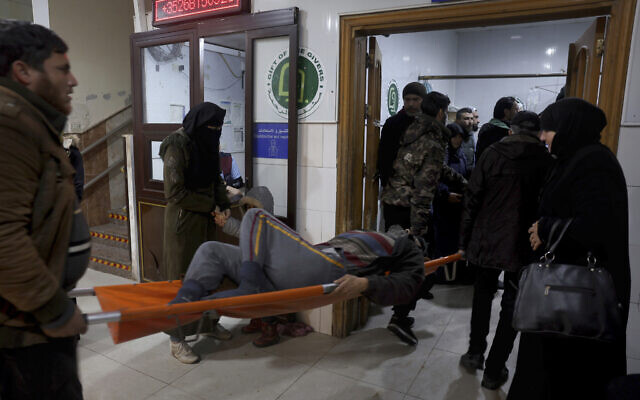 People carry a man injured in an earthquake into the al-Rahma Hospital in the town of Darkush, Idlib province, northern Syria, Feb. 6, 2023. (AP Photo/Ghaith Alsayed)