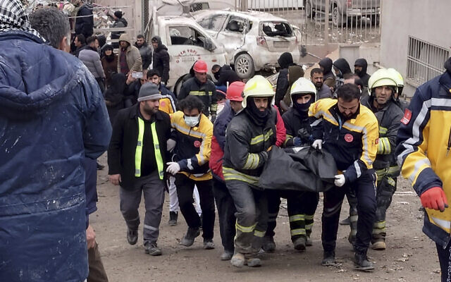 Firefighters carry the body of a victim in Diyarbakir, in southeastern Turkey, Feb. 6, 2023. (AP Photo/Mahmut Bozarsan)