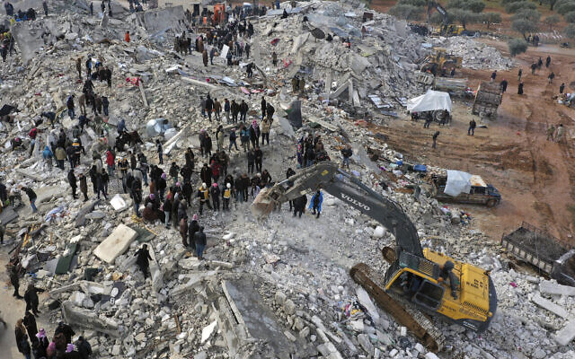 Civil defense workers and residents search through the rubble of collapsed buildings in the town of Harem near the Turkish border, Idlib province, Syria, Feb. 6, 2023. (AP Photo/Ghaith Alsayed)