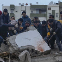 Men search for people among the debris in a destroyed building in Adana, Turkey, February 6, 2023. (AP Photo/Khalil Hamra)