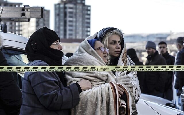 Three women watch the emergency teams as they search for survivors in the rubble of a destroyed building in Gaziantep, southeastern Turkey, Tuesday, February 7, 2023. (AP Photo/Mustafa Karali)