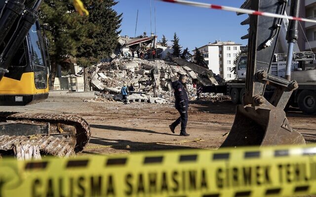 A policeman patrols a block where three building collapsed, in Gaziantep, southeastern Turkey, Tuesday, February 7, 2023. (AP Photo/Mustafa Karali)