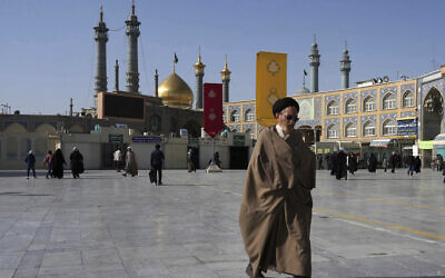 A cleric walks in front of the Fatima Masumeh Shrine in Qom, Iran, February 7, 2023. (AP/Vahid Salemi)