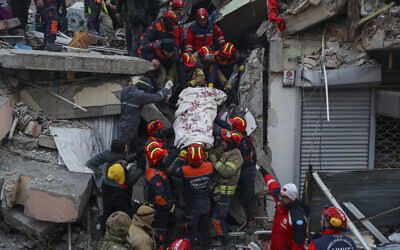 Turkish rescue workers carry Ergin Guzeloglan, 36, to an ambulance after pulled him out from a collapsed building five days after an earthquake in Hatay, southern Turkey, early February 11, 2023. (AP Photo/Can Ozer)