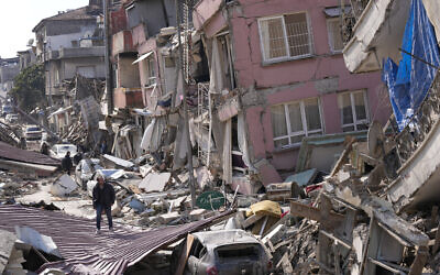 A man walks over debris of collapsed buildings in Hatay, Turkey, February 11, 2023. (Hussein Malla/AP)