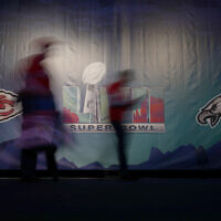 People are blurred by a long exposure as they arrive at the NFL Experience on February 11, 2023, in Phoenix, Arizona. (AP Photo/Charlie Riedel)