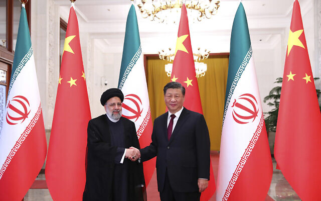 Iranian President Ebrahim Raisi, left, shakes hands with his Chinese counterpart Xi Jinping in an official welcoming ceremony in Beijing, February 14, 2023. (Iranian Presidency Office via AP)