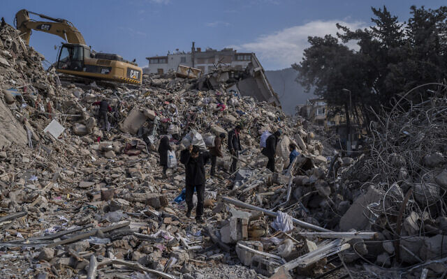 People walk through the rubble of destroyed buildings in Antakya, southeastern Turkey, February 15, 2023. (AP Photo/Bernat Armangue)