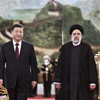 In this photo released by Xinhua News Agency, visiting Iranian President Ebrahim Raisi, right, walks with Chinese President Xi Jinping after reviewing an honor guard during a welcome ceremony at the Great Hall of the People in Beijing, Tuesday, February 14, 2023. (Yan Yan/Xinhua via AP, File)