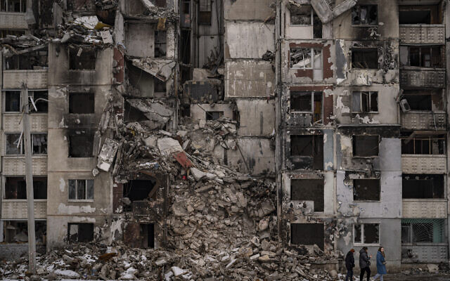 Women walk by a building damaged by Russian shelling in the Saltivka district of Kharkiv, Ukraine, February 16, 2023. (AP Photo/Vadim Ghirda)