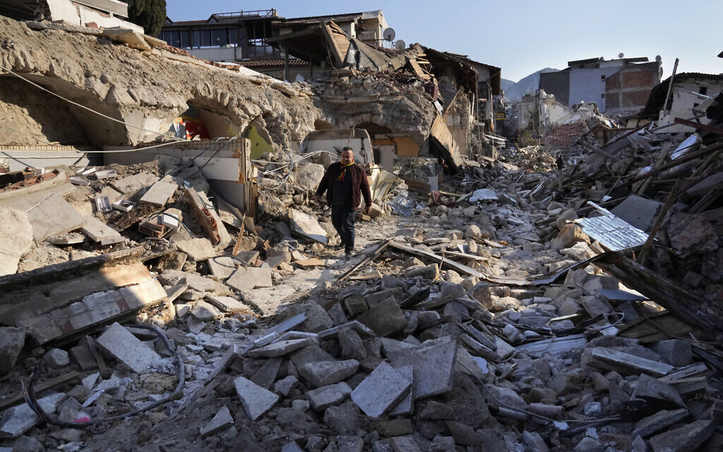 A Turkish man, walks on the debris of the heritage houses that destroyed during the devastated earthquake, in the old city of Antakya, southern Turkey, Monday, February 13, 2023. (AP/Hussein Malla)