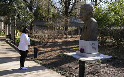 Dawn Thomas of Kankakee Ill., says a short prayer in front of a statue of former President Jimmy Carter at the Jimmy Carter Presidential Library and Museum on Sunday, Feb. 19, 2023, in Atlanta. (AP/John Bazemore)