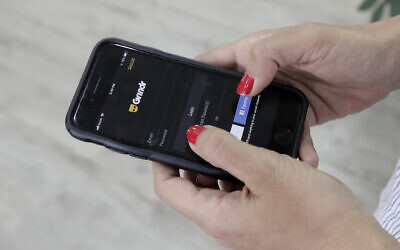 A person looks at the Grindr app on her mobile phone in Beirut, Lebanon, May 29, 2019. (AP Photo/Hassan Ammar, File)