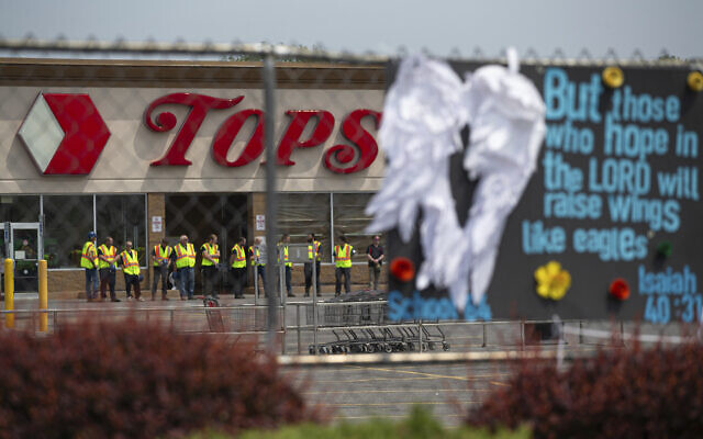 FILE - Investigators stand outside during a moment of silence for the victims of the Buffalo supermarket shooting outside the Tops Friendly Market on May 21, 2022, in Buffalo, New York. (AP Photo/Joshua Bessex, File)