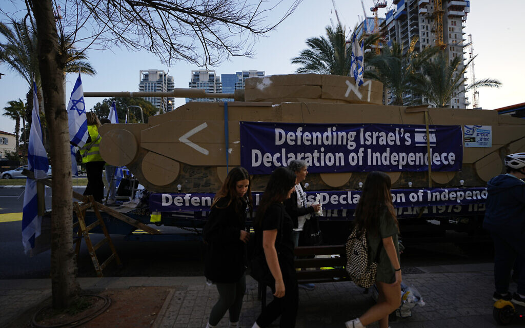 Israelis display a representation of a tank at a protest against government plans to overhaul the judicial system, in Tel Aviv, Feb. 25, 2023. (AP Photo/ Ariel Schalit)