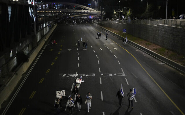 Graffiti reading 'Bibi, traitor' is written across the Ayalon highway during an anti-government protest in Tel Aviv, Feb. 25, 2023. (AP Photo/Ariel Schalit)