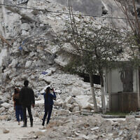 People stand by a building destroyed in recent earthquake in Aleppo, Syria,  February 27, 2023. (Omar Sanadiki/AP)
